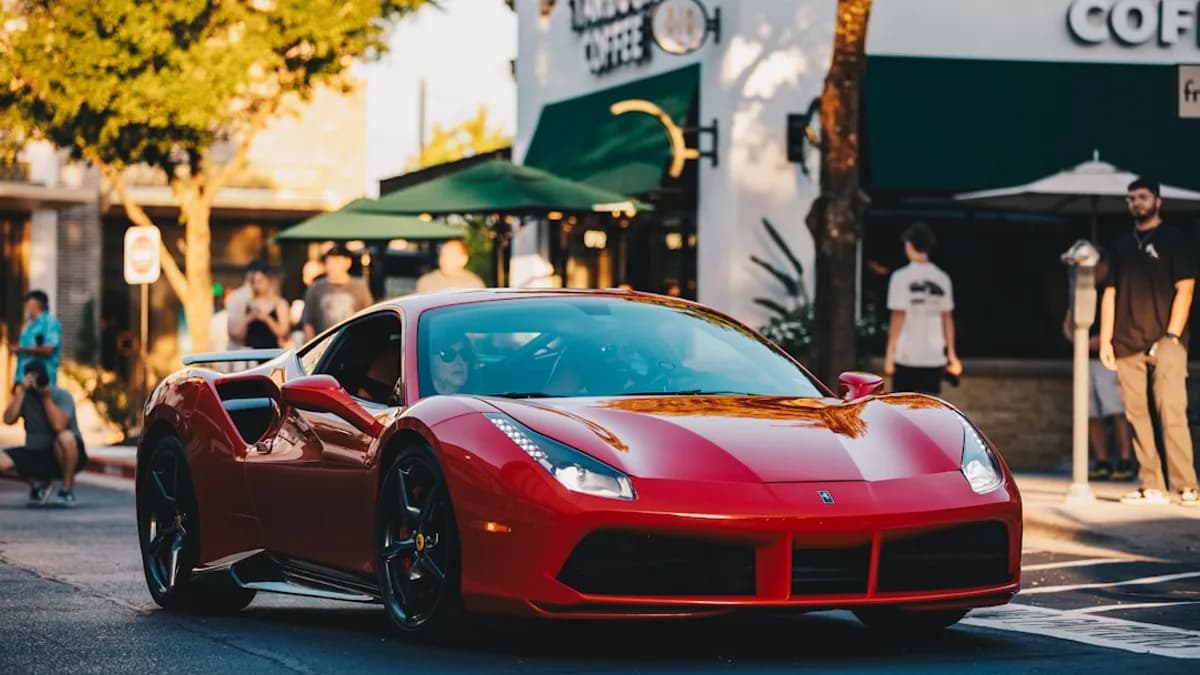 Red sports car driving on a city street