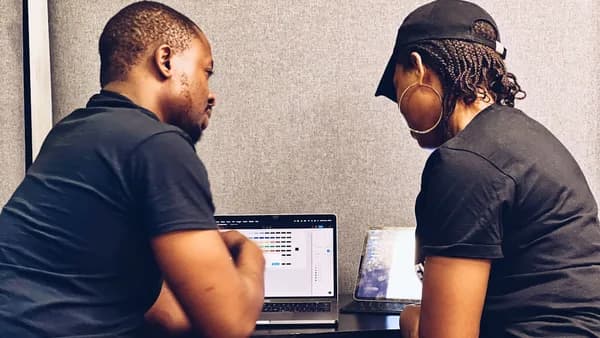 a couple of people sitting at a table with a laptop