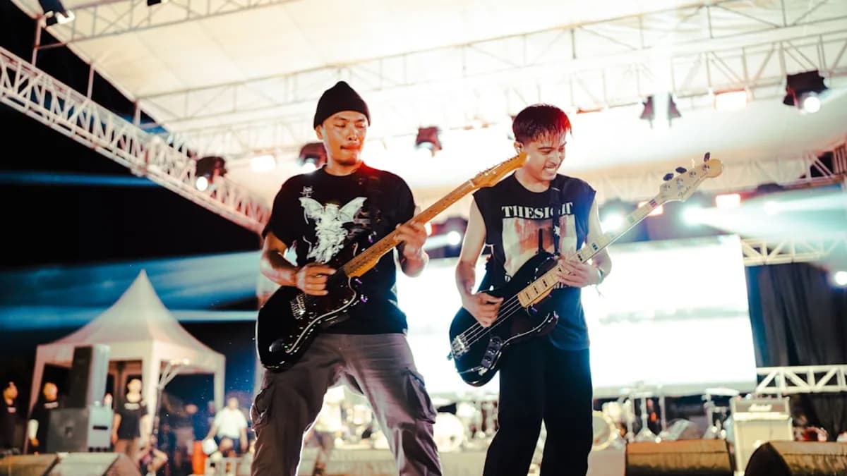 Two guitarists play on a stage.
