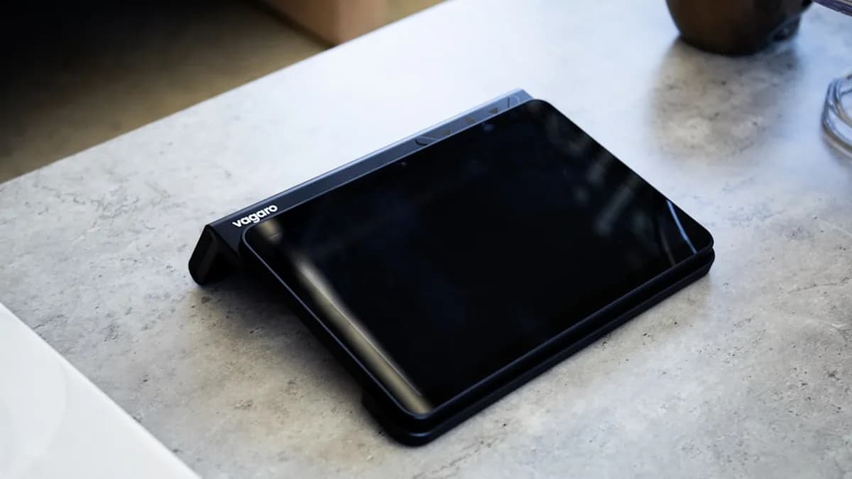 A black tablet sits on a gray table.