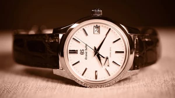 A watch sitting on top of a wooden table