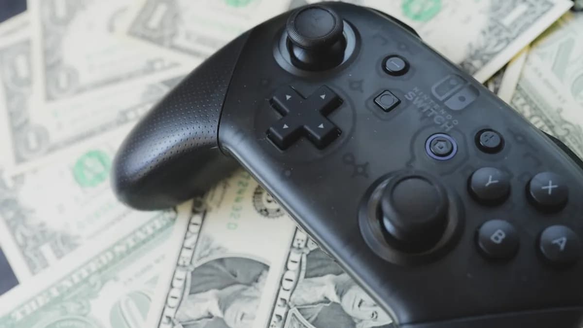 a video game controller sitting on top of a pile of money