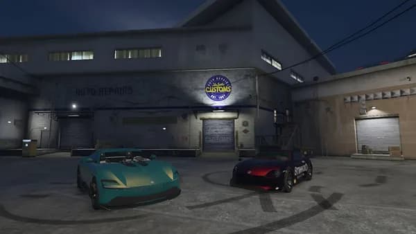 Two cars parked in front of a building at night