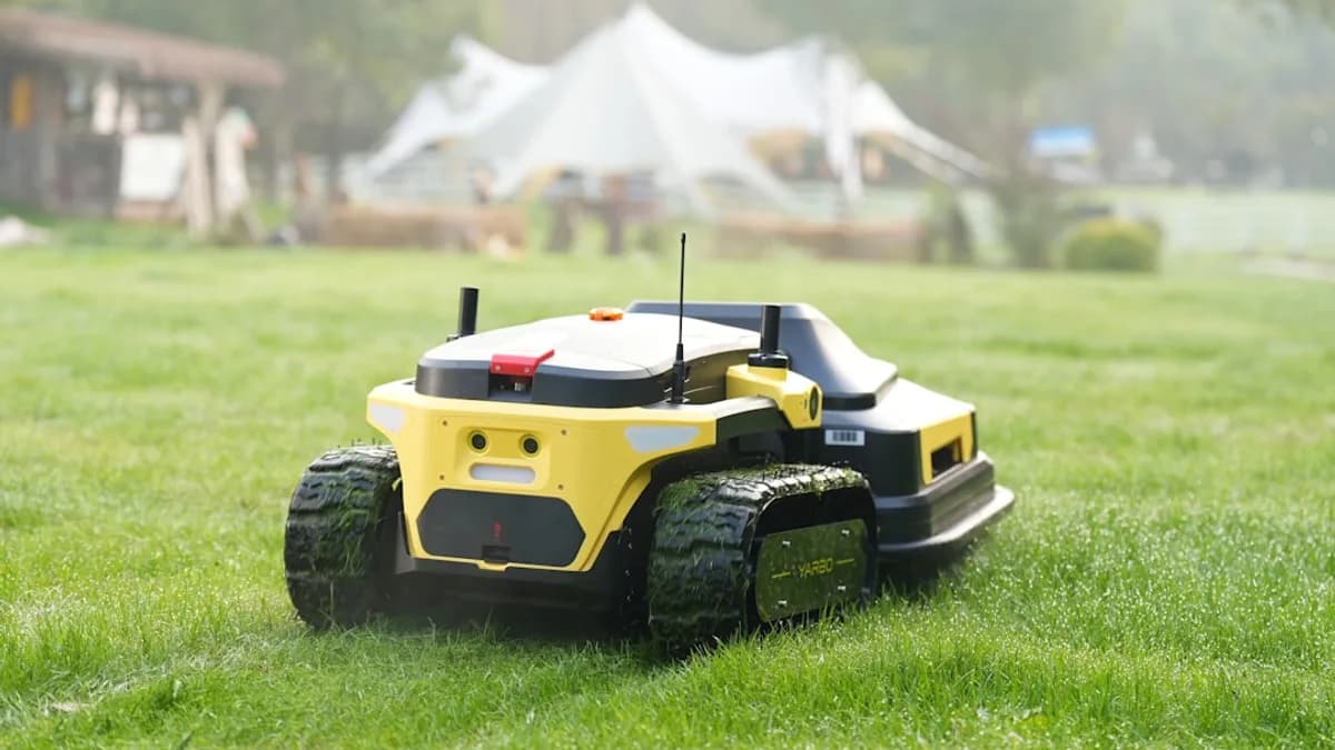 Robot lawnmower cuts grass in a backyard.
