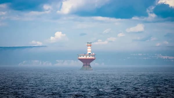 red and white tower surrounded by body of water
