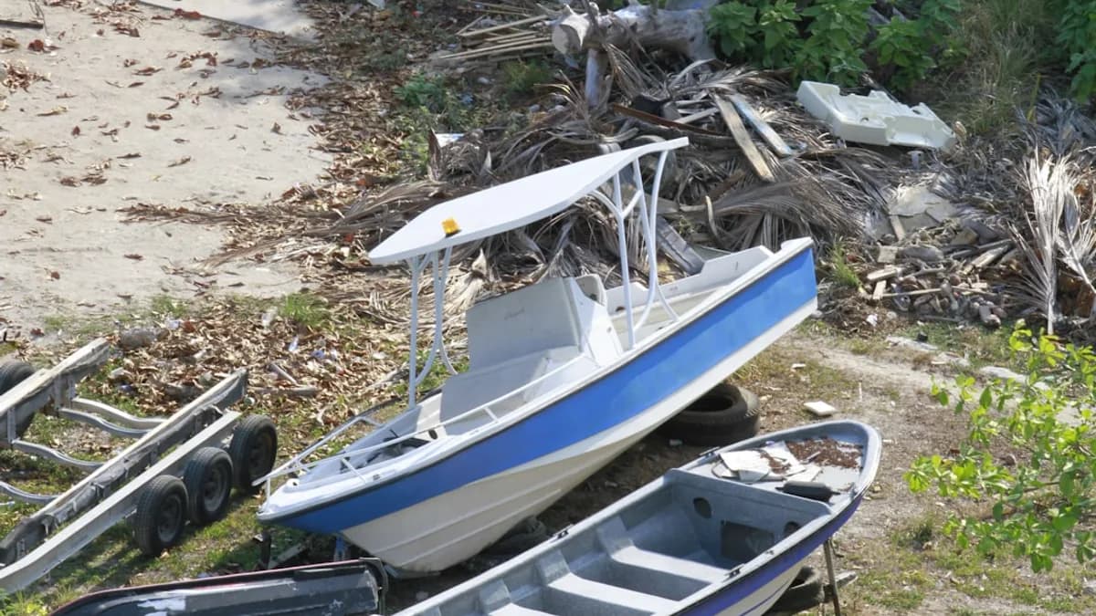 a blue and white boat sitting on top of a beach