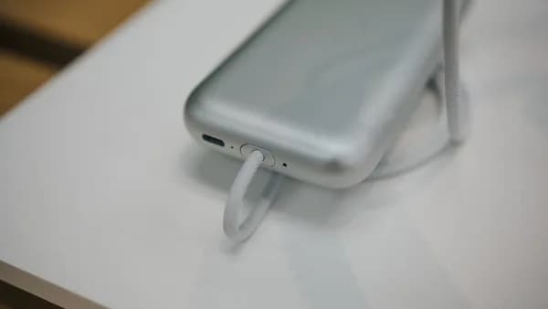 a cell phone plugged into a charger on a table