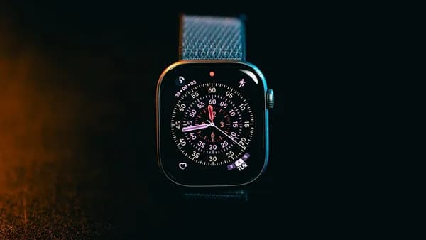 A smartwatch with a colorful face on a dark background