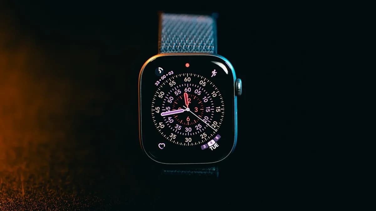 A smartwatch with a colorful face on a dark background