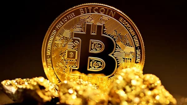 a bitcoin sitting on top of a pile of gold nuggets