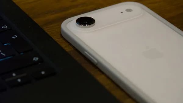 White iPhone with clear case next to laptop