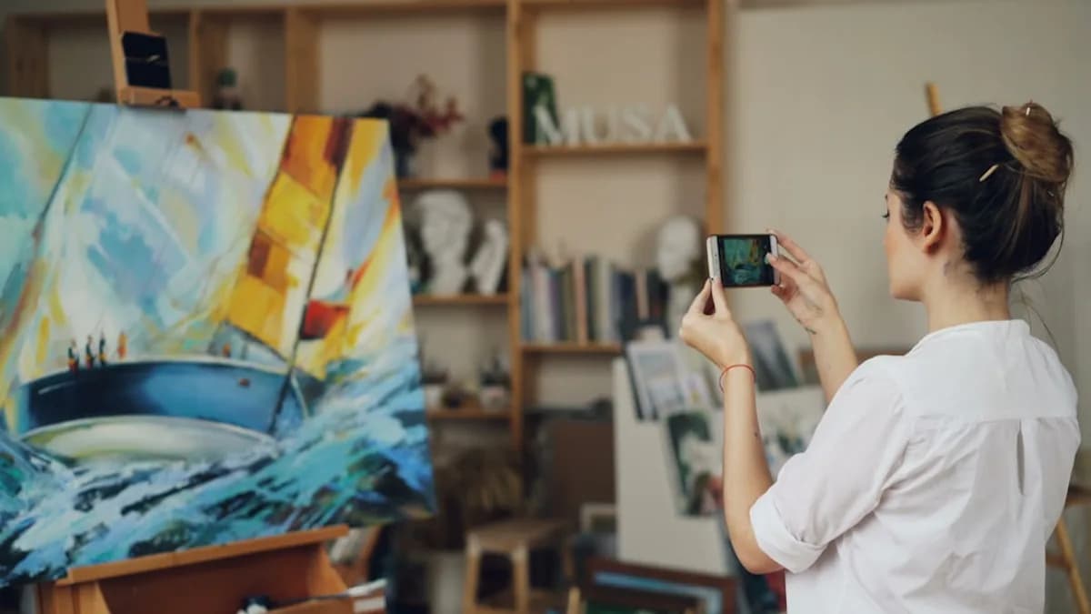 Woman takes a photo of her painting.