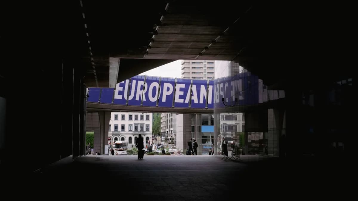 a person walking under a bridge with a european sign above it