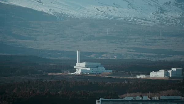 a large white building sitting in the middle of a forest