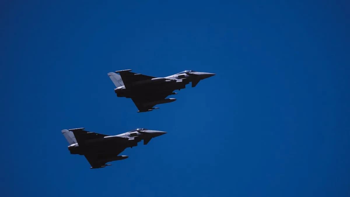 two fighter jets flying through a blue sky