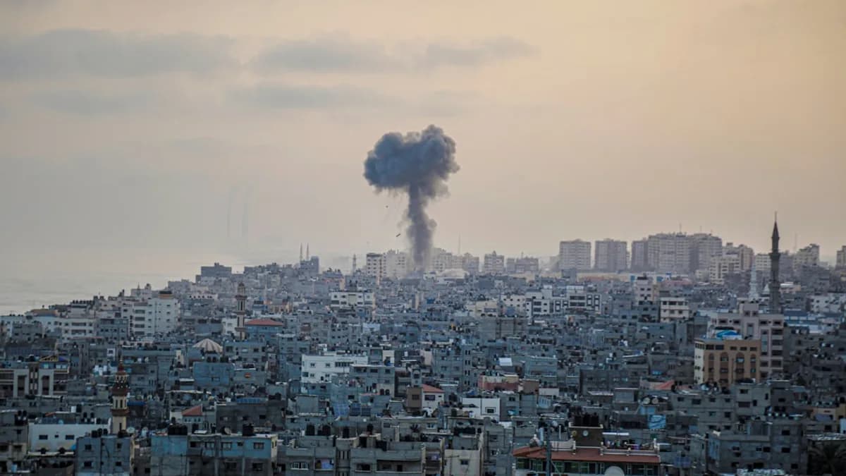 smoke billows from a factory in a city