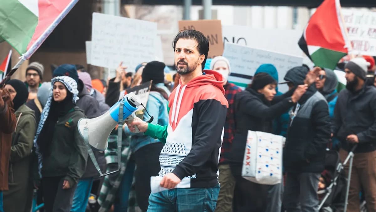 a man holding a megaphone in front of a crowd of people