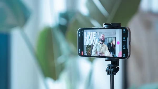 Smartphone recording a man speaking on live stream.