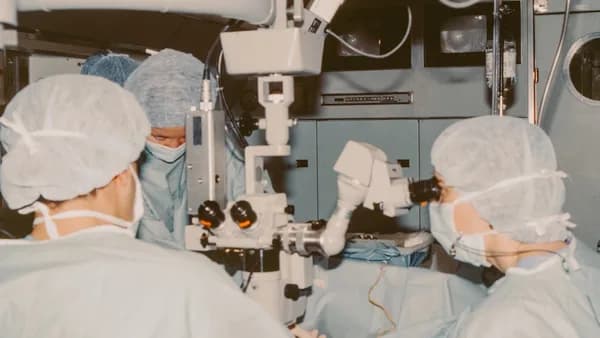 Surgeons operating with a microscope