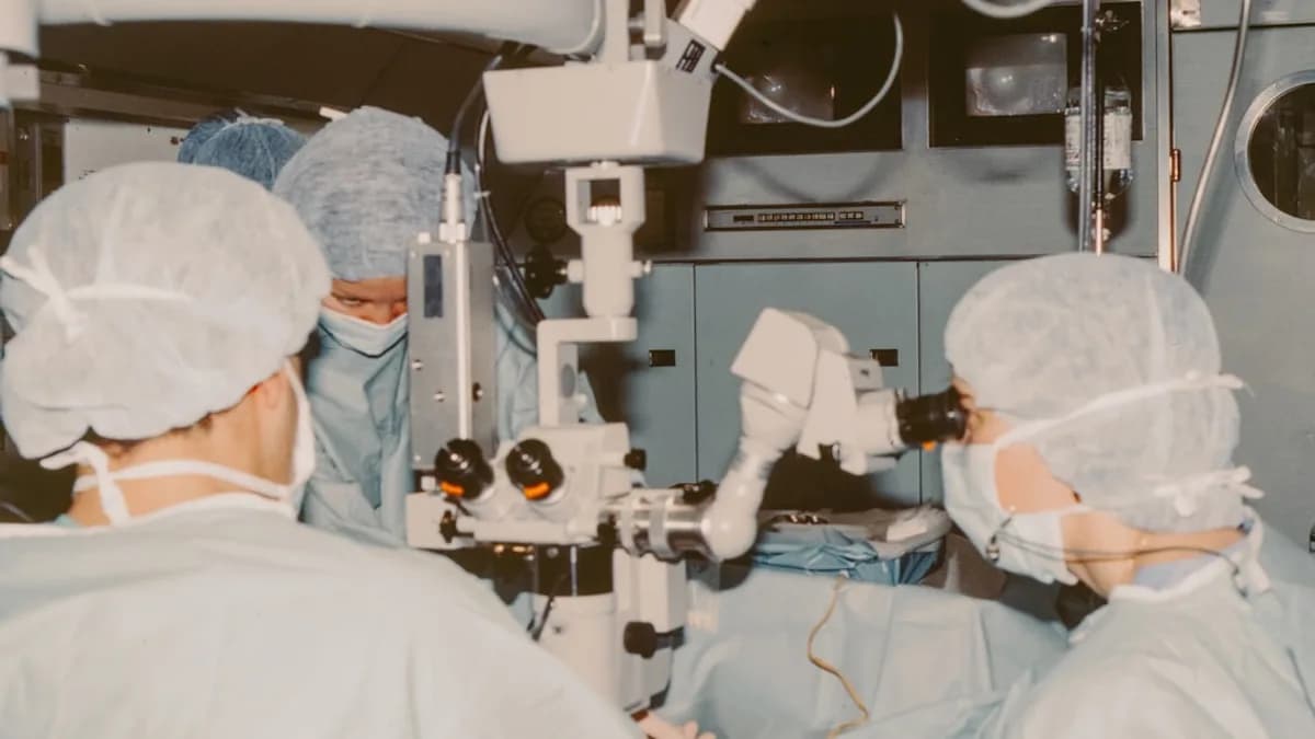 Surgeons operating with a microscope