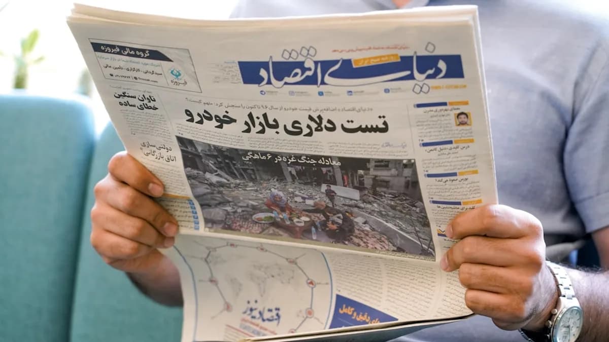 a man holding a newspaper with a picture of a man on it