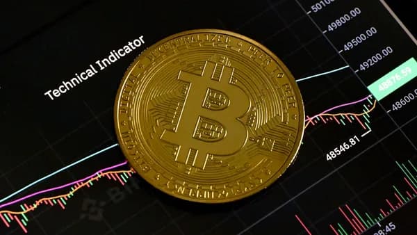 a bit coin sitting on top of a stock chart