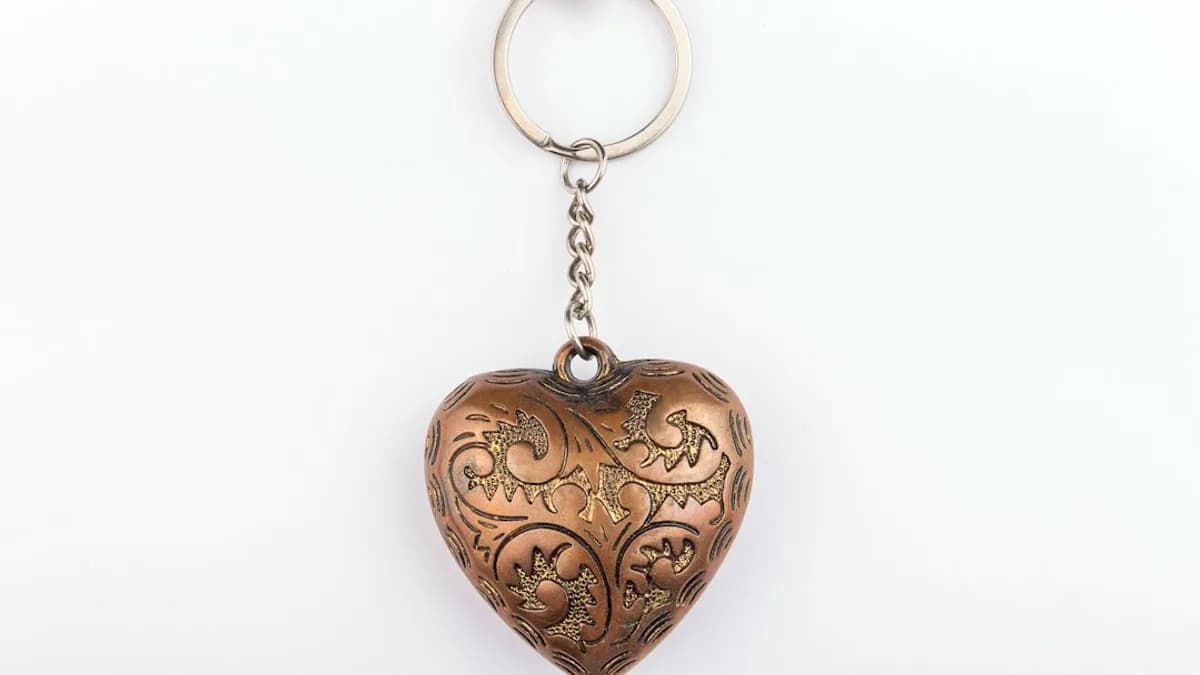 A metal heart shaped keychain hanging from a chain