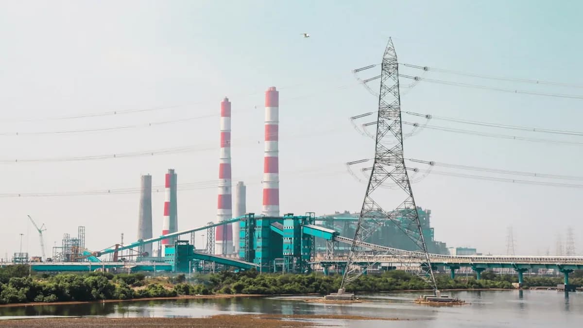 a power plant with a bridge in the background