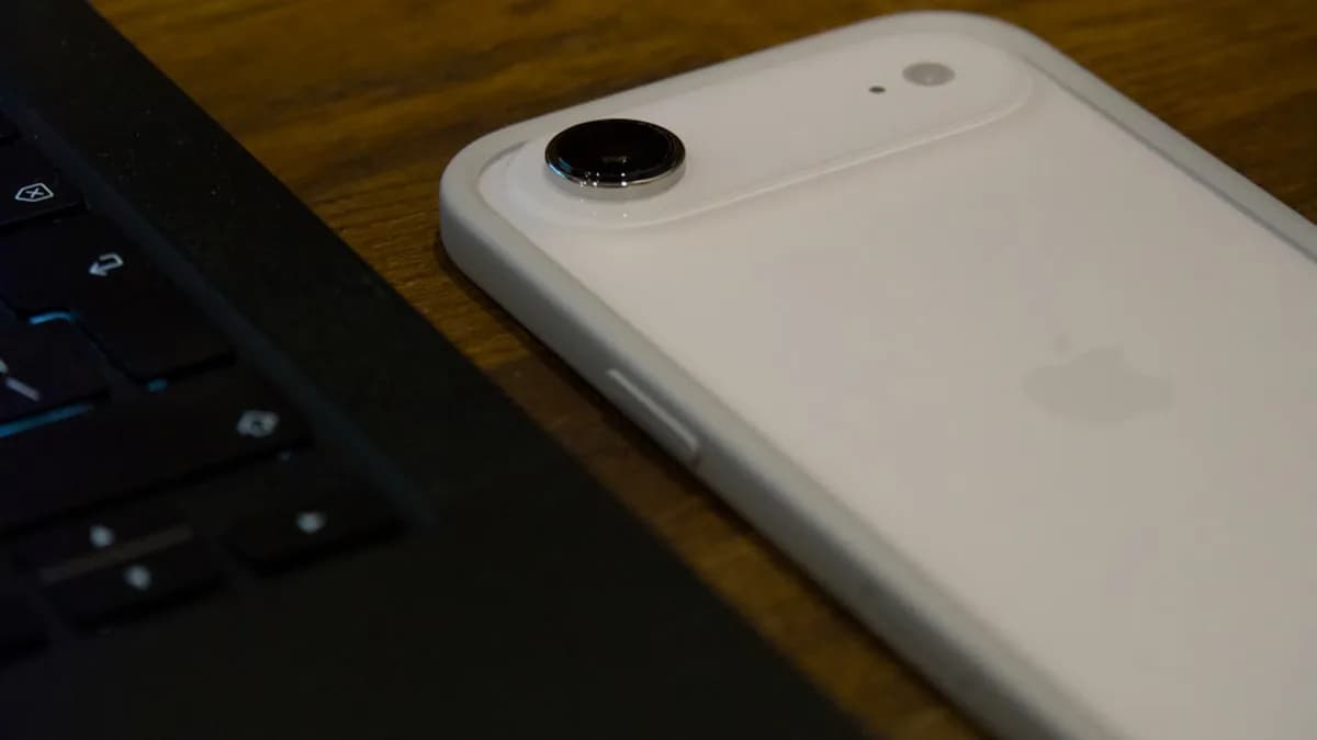 White iPhone with clear case next to laptop