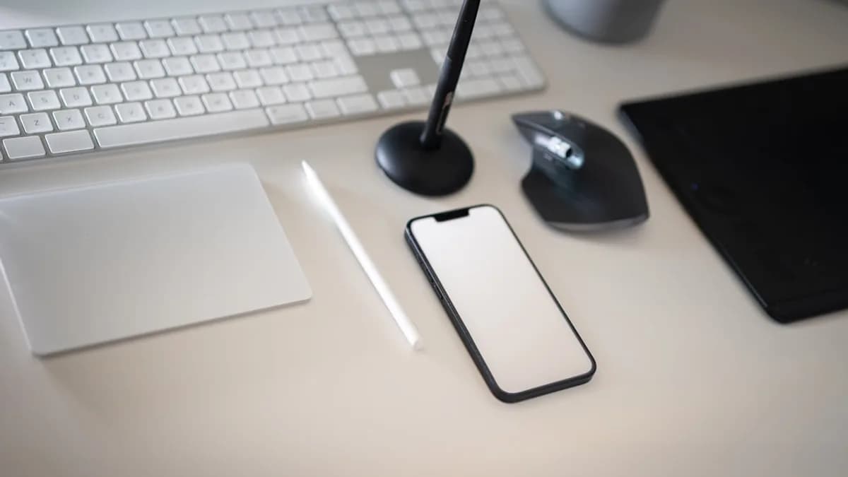 a cell phone sitting on top of a desk next to a keyboard
