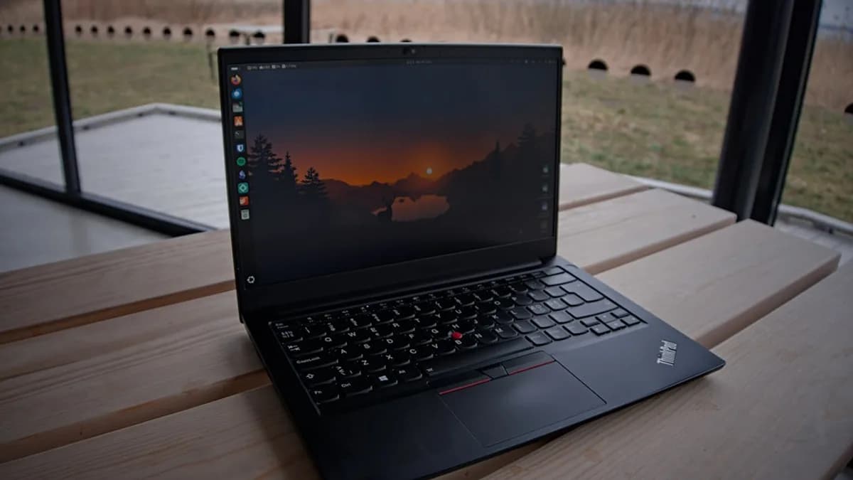 A laptop sits open on a wooden surface.
