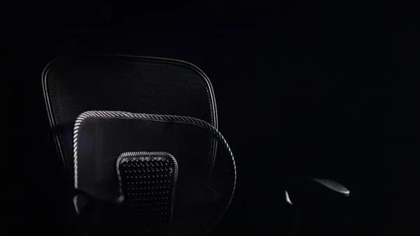 a black office chair sitting in the dark