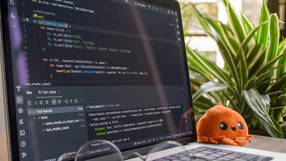 Laptop screen displaying code with a small octopus toy.
