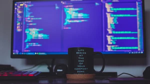flat screen monitor and black ceramic mug