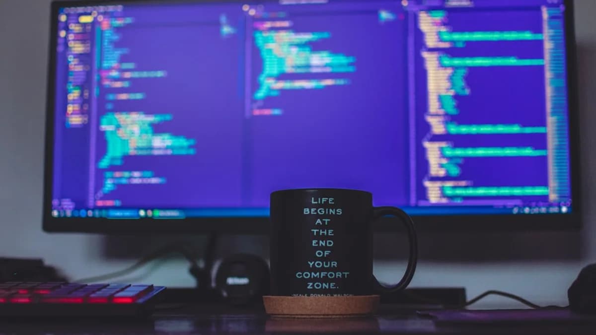 flat screen monitor and black ceramic mug