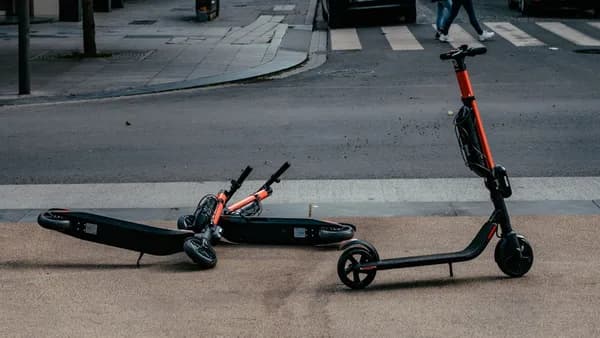 motorized scooters parked near road during daytime