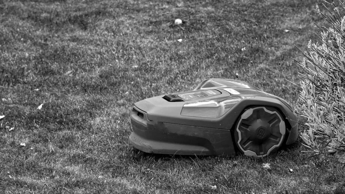 A black and white photo of a lawn mower laying on the ground