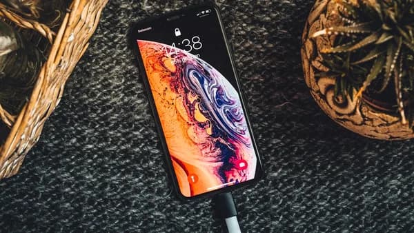 gold iPhone Xs on black textile