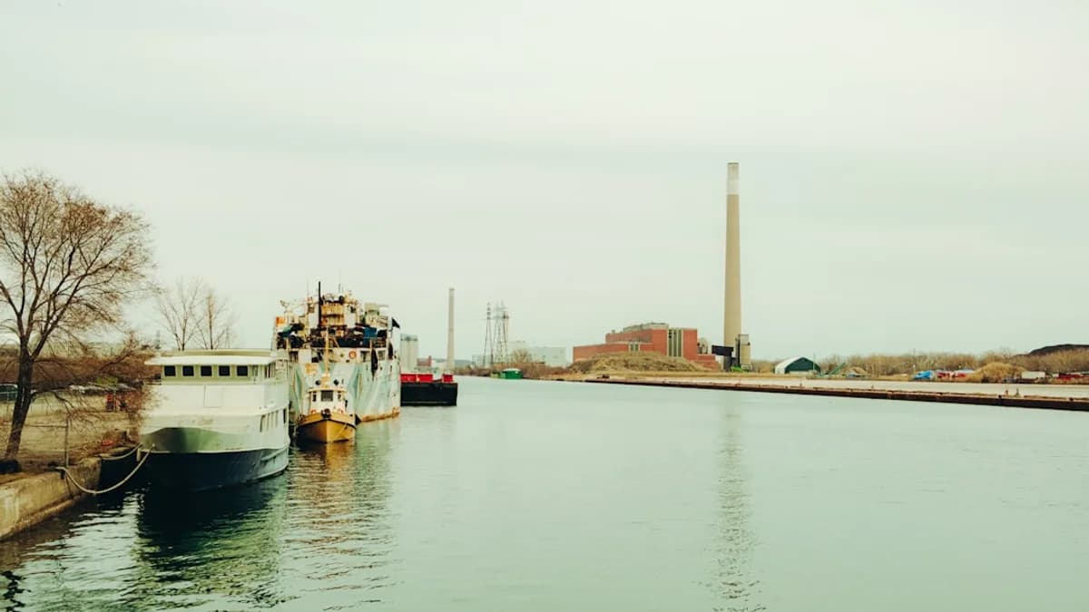 Ships docked in a canal with industrial buildings