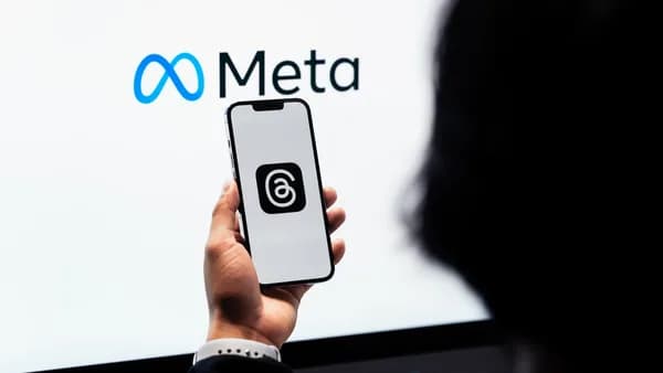 a person holding a cell phone in front of a large screen