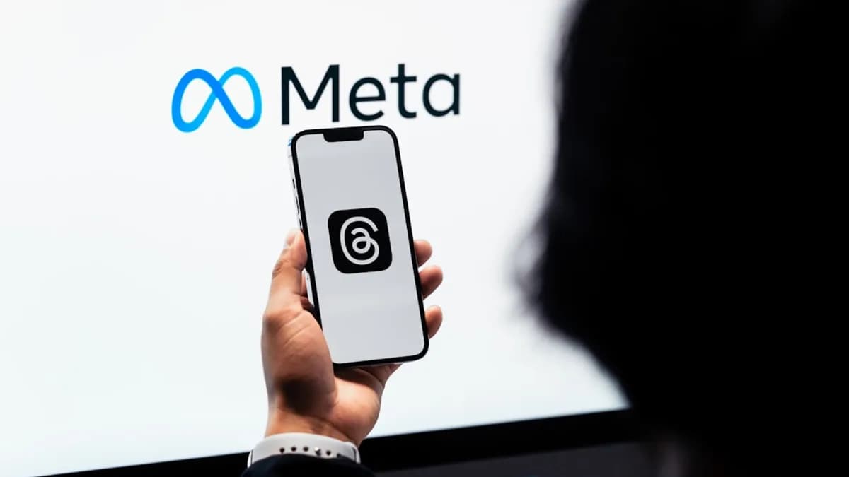 a person holding a cell phone in front of a large screen