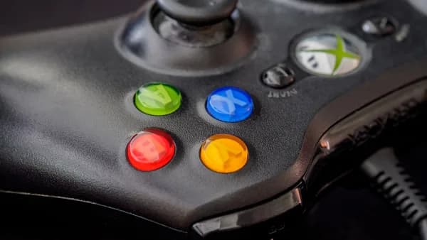 black xbox game controller with green orange yellow and red buttons