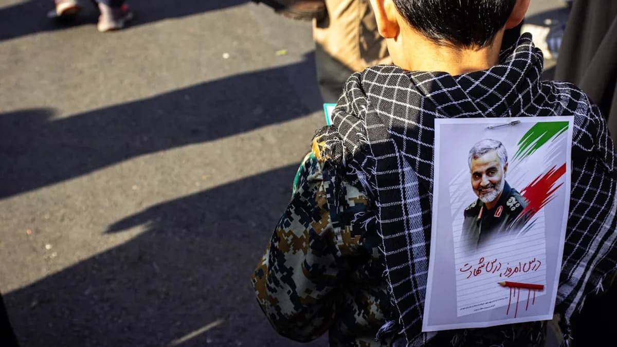 boy in black hoodie with photo of man in back