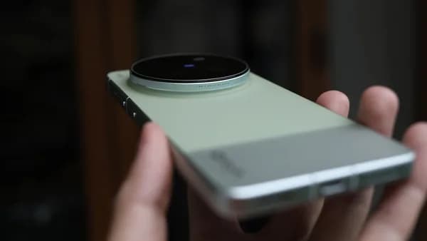 Hand holding a modern smartphone with large camera lens.