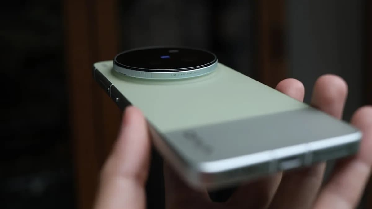 Hand holding a modern smartphone with large camera lens.