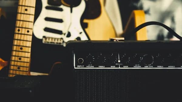 black guitar amplifier beside electric guitar