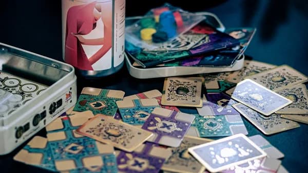 a can of beer sitting next to a pile of playing cards