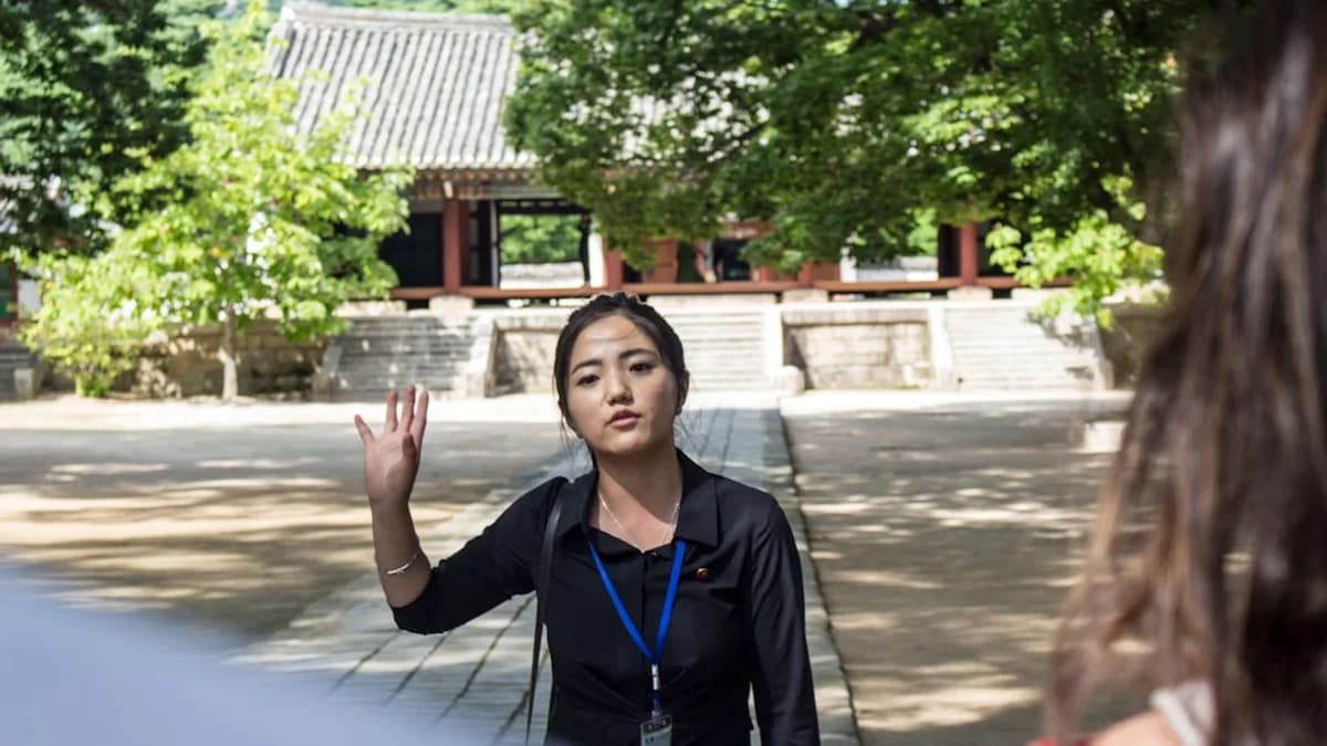 woman in black jacket standing near green trees during daytime