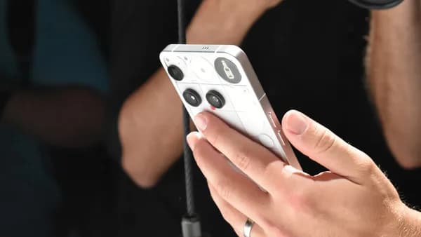 Person holding a white smartphone with a camera lens