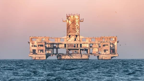 brown concrete building on body of water during daytime